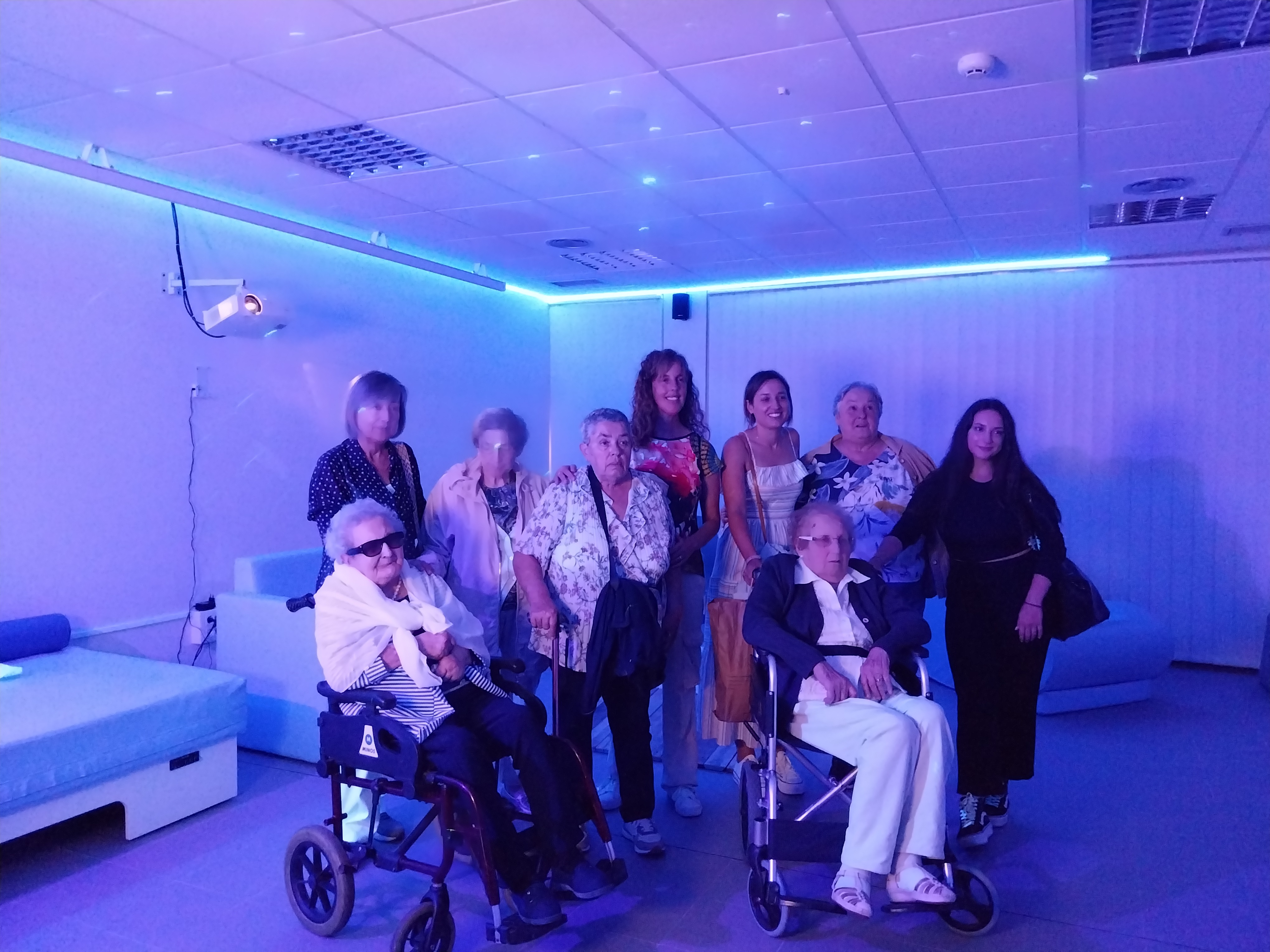 Personas usuarias y personal del centro de día de Luanco en la sala multisensorial.